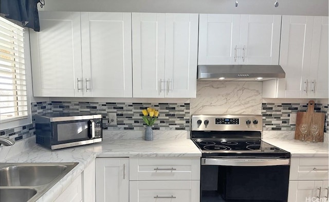 kitchen featuring appliances with stainless steel finishes, white cabinetry, sink, backsplash, and exhaust hood