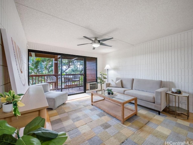 living room with ceiling fan and a textured ceiling