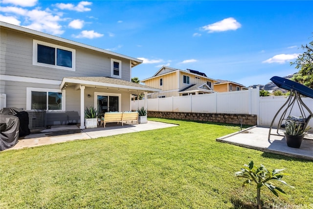 back of house featuring cooling unit, a lawn, and a patio