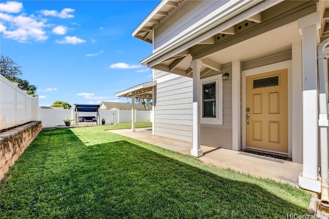 entrance to property with a patio and a lawn