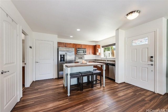 kitchen featuring a center island, tasteful backsplash, a kitchen breakfast bar, dark hardwood / wood-style flooring, and stainless steel appliances