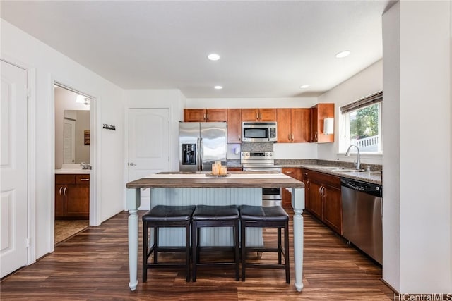 kitchen with sink, dark wood-type flooring, a center island, decorative backsplash, and stainless steel appliances