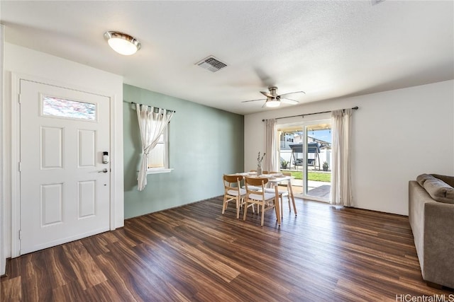 dining area featuring a textured ceiling, dark hardwood / wood-style floors, and ceiling fan