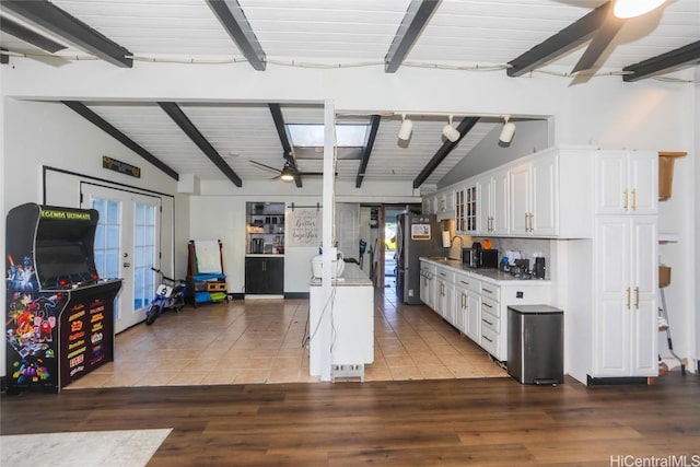 kitchen featuring stainless steel fridge, ceiling fan, white cabinetry, lofted ceiling with beams, and french doors