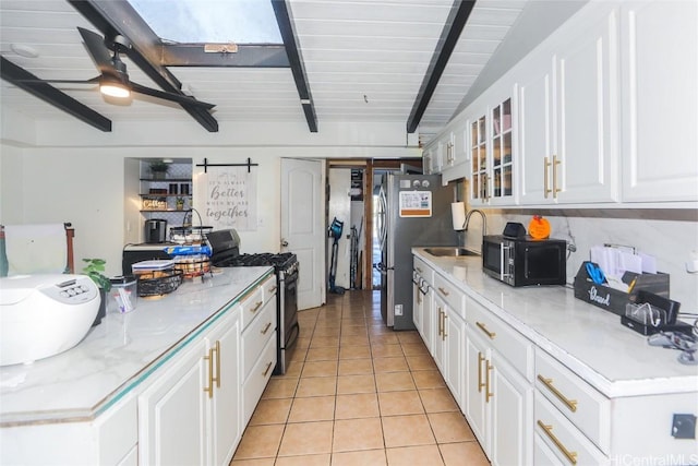 kitchen featuring light tile patterned flooring, stainless steel appliances, sink, and white cabinets