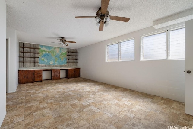 interior space with a textured ceiling and built in desk