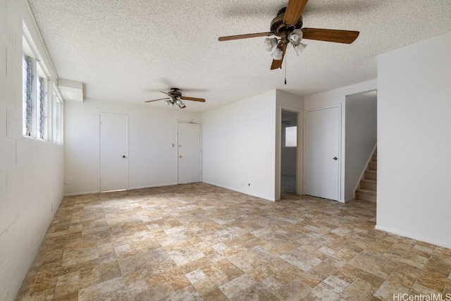 interior space with a textured ceiling and ceiling fan