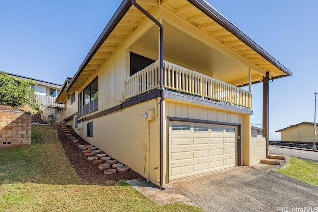 view of home's exterior featuring a balcony and a garage