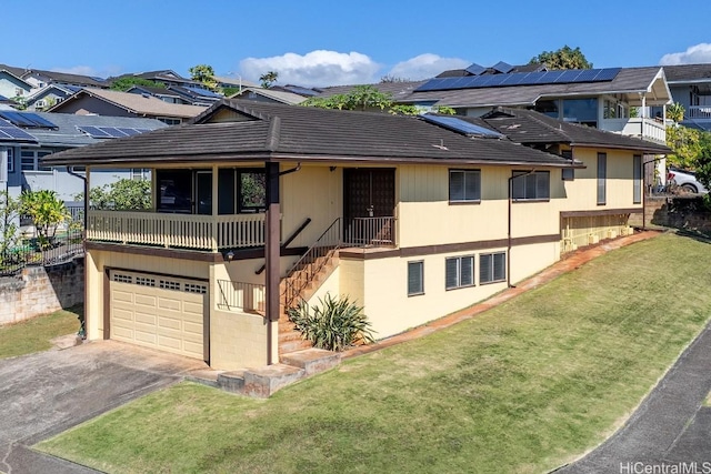 view of front of house featuring a garage, a front lawn, and solar panels