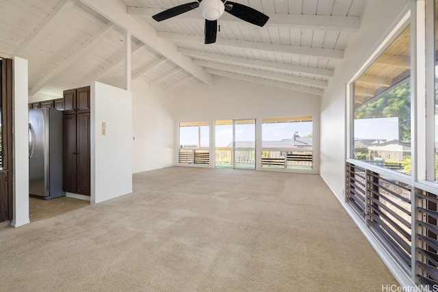 unfurnished living room with ceiling fan, high vaulted ceiling, beam ceiling, and light carpet