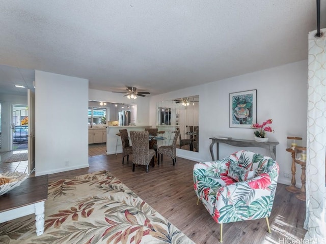 dining area with ceiling fan, wood-type flooring, a textured ceiling, and plenty of natural light