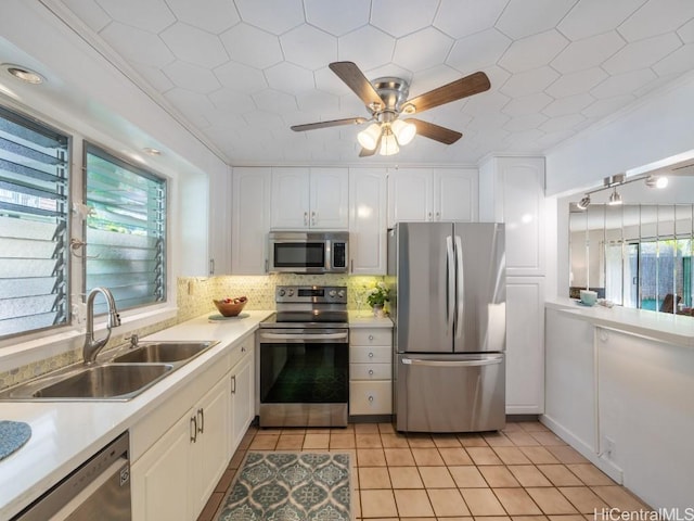 kitchen with white cabinetry, sink, decorative backsplash, ornamental molding, and stainless steel appliances