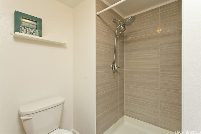 bathroom with toilet and tiled shower