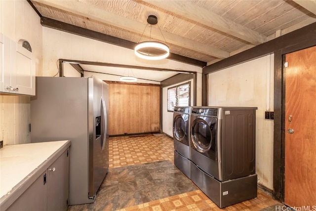 laundry room with cabinets, washing machine and clothes dryer, wood ceiling, and wooden walls