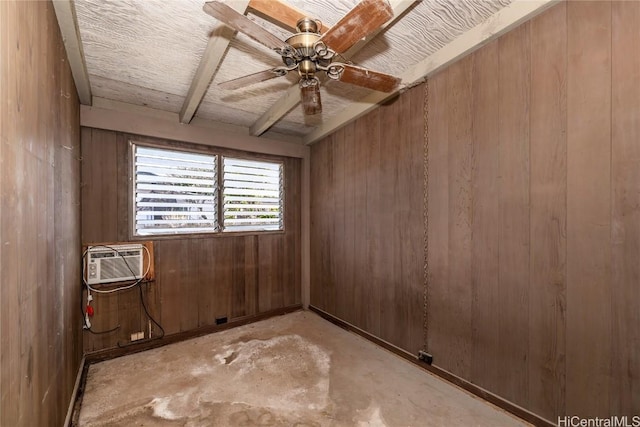 unfurnished room with beam ceiling, wood walls, ceiling fan, and a wall mounted air conditioner