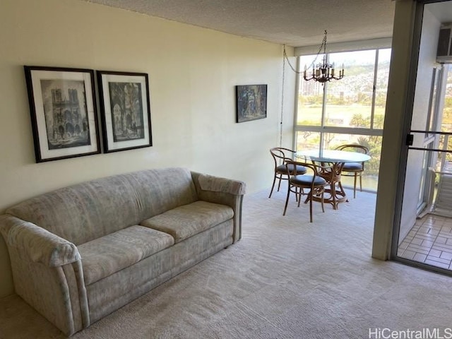 living room featuring an inviting chandelier, light colored carpet, and a textured ceiling