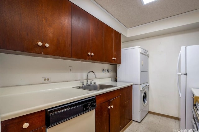 clothes washing area with stacked washer and dryer, sink, and a textured ceiling