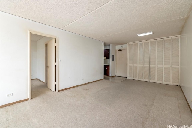 empty room featuring light carpet and a textured ceiling