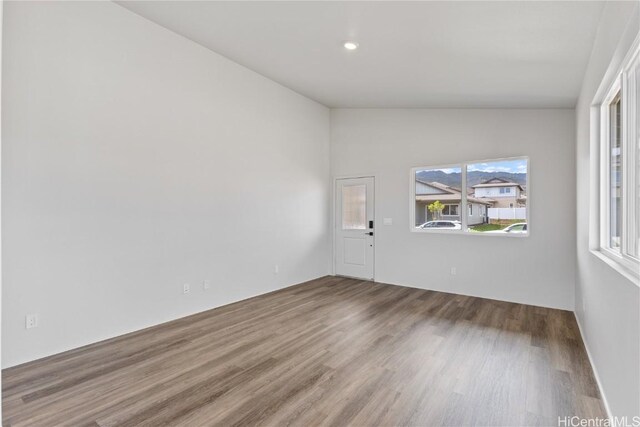 empty room with vaulted ceiling and wood finished floors