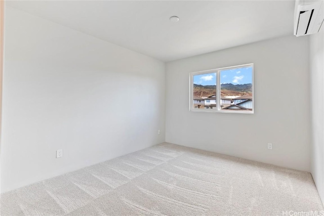 spare room with a wall mounted air conditioner and light colored carpet