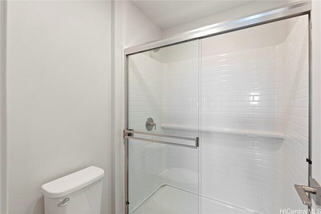 full bathroom with a stall shower and toilet