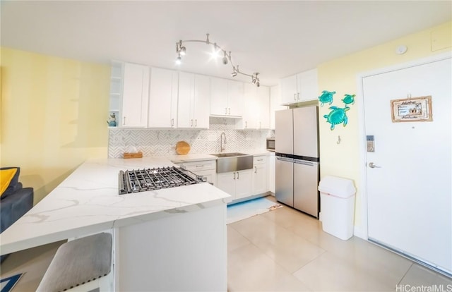 kitchen featuring white cabinetry, stainless steel appliances, kitchen peninsula, and sink