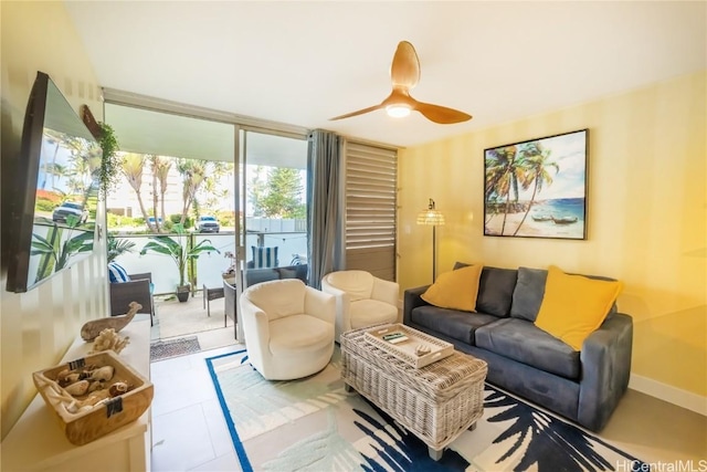 tiled living room featuring expansive windows and ceiling fan