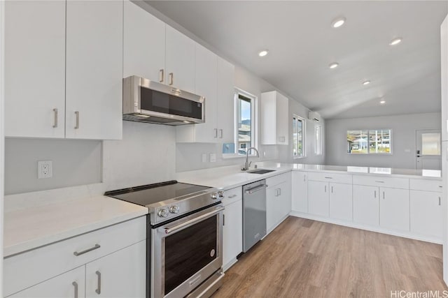 kitchen featuring white cabinetry, sink, stainless steel appliances, and light wood-type flooring