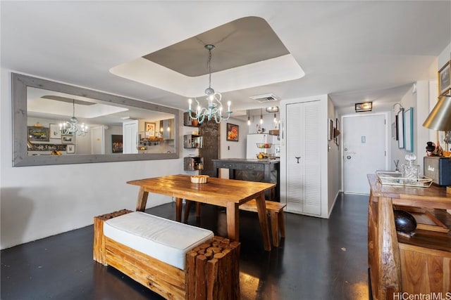 dining space with a notable chandelier and a tray ceiling