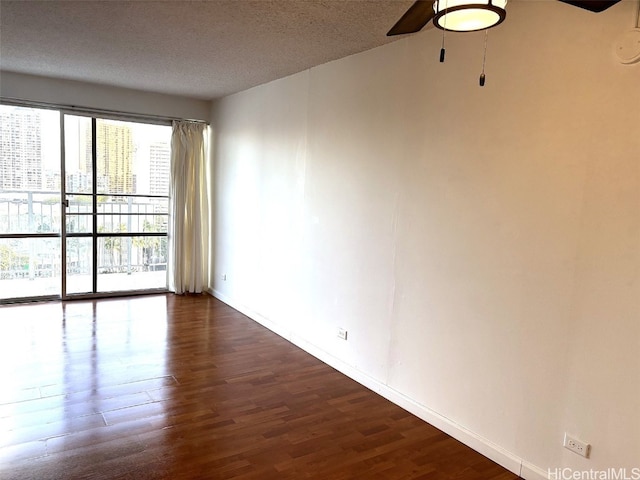 empty room featuring a textured ceiling and dark hardwood / wood-style flooring