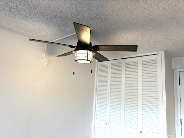 details featuring ceiling fan and a textured ceiling