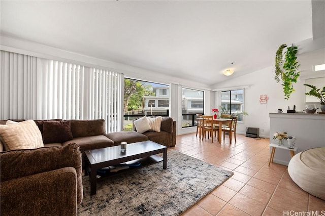 living room featuring vaulted ceiling, a wealth of natural light, and light tile patterned floors