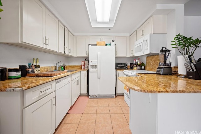 kitchen with white cabinetry, light tile patterned floors, white appliances, and light stone counters