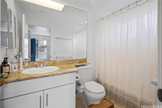 bathroom with tile patterned flooring, vanity, and toilet