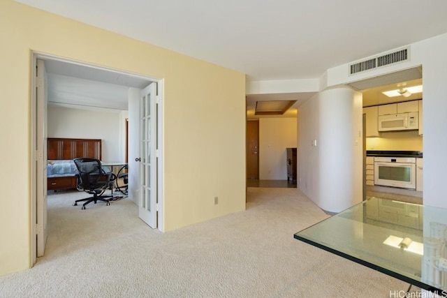 hallway featuring light colored carpet