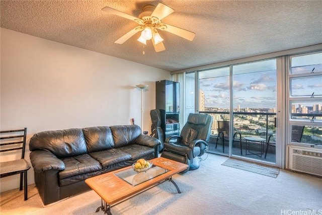 carpeted living room with a textured ceiling, a wall of windows, and ceiling fan