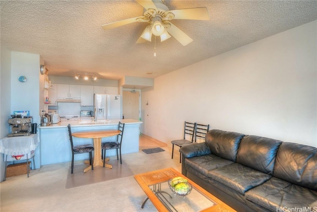 living room with ceiling fan and a textured ceiling