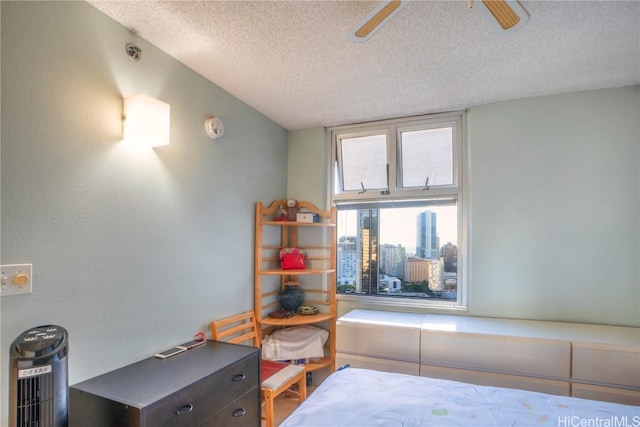 bedroom with ceiling fan and a textured ceiling