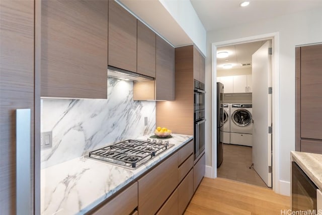 kitchen with light hardwood / wood-style floors, stainless steel gas cooktop, backsplash, wine cooler, and independent washer and dryer