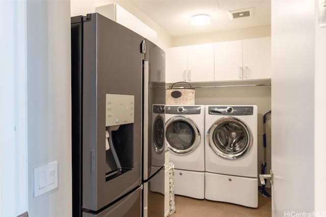 laundry room with light tile patterned floors, cabinets, and independent washer and dryer