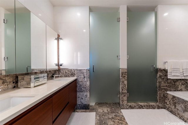 bathroom with tile walls, vanity, and plus walk in shower