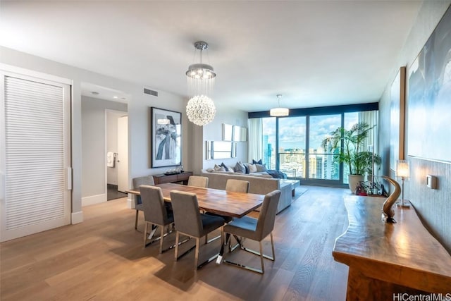 dining area with a chandelier, light hardwood / wood-style flooring, and expansive windows