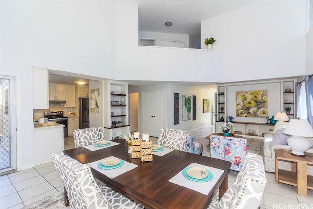 dining area featuring light tile patterned floors and a high ceiling