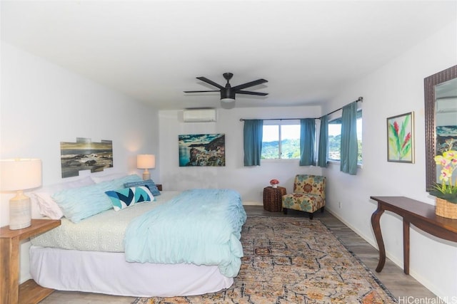 bedroom with ceiling fan, hardwood / wood-style flooring, and a wall mounted AC