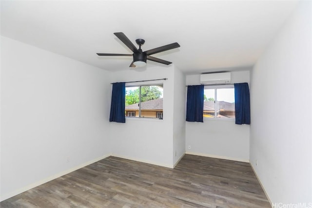 spare room featuring ceiling fan, dark wood-type flooring, and a wall unit AC