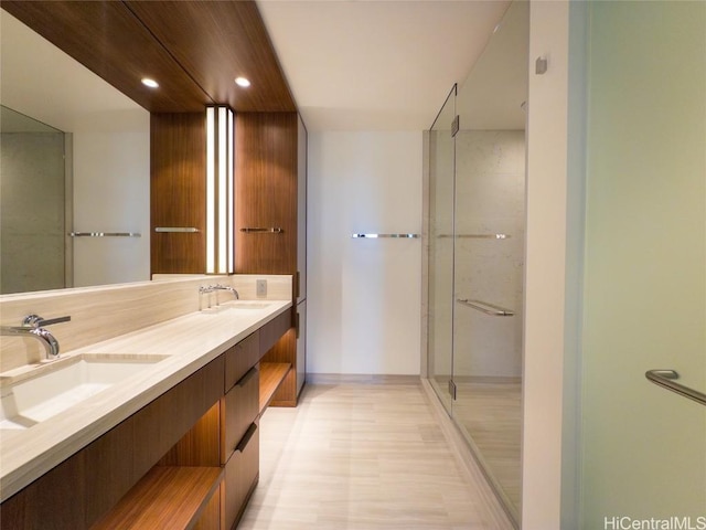 bathroom with a shower with shower door and vanity