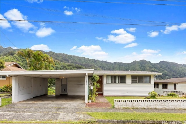 view of front of property featuring a carport, a mountain view, and driveway