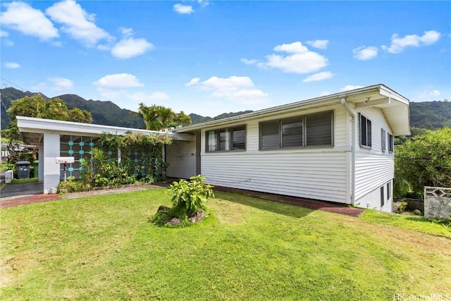 rear view of property with a mountain view and a yard