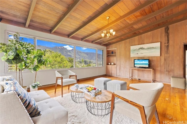 living room with a notable chandelier, vaulted ceiling with beams, wood ceiling, wood walls, and wood finished floors