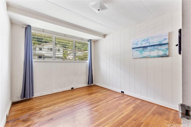 spare room featuring wood finished floors and baseboards